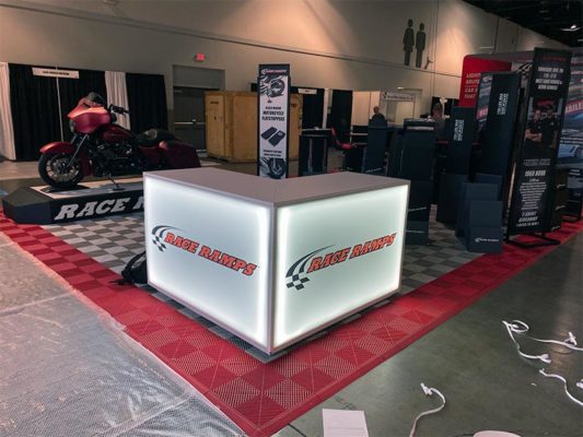 Trade Show Counter Rental Package C3 - LED L-Shaped Reception Counter - Race Ramps - LV Exhibit Rentals in Las Vegas