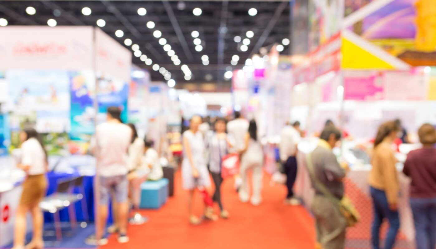 blurred tradeshow with multiple booths in the background